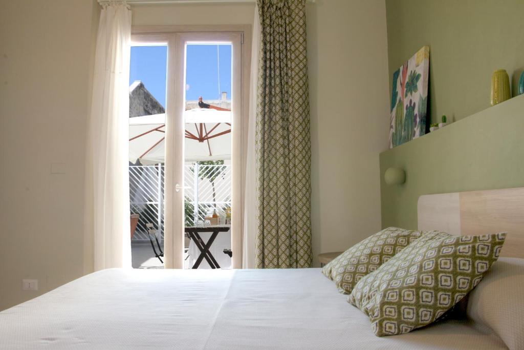 特拉尼B&B Radici的一间卧室设有一张床和一个滑动玻璃门