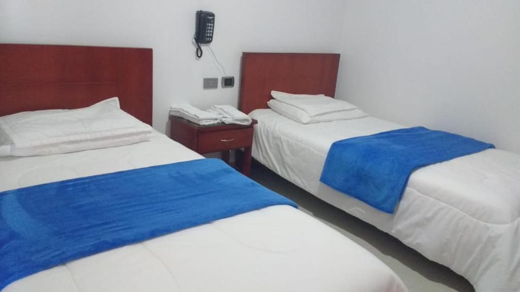 BaranoaHotel Manzanares Baranoa的一间设有两张蓝色和白色床铺的客房