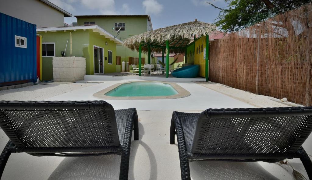 奥拉涅斯塔德Pista Q hostel and apartments的两把椅子和一个庭院内的游泳池