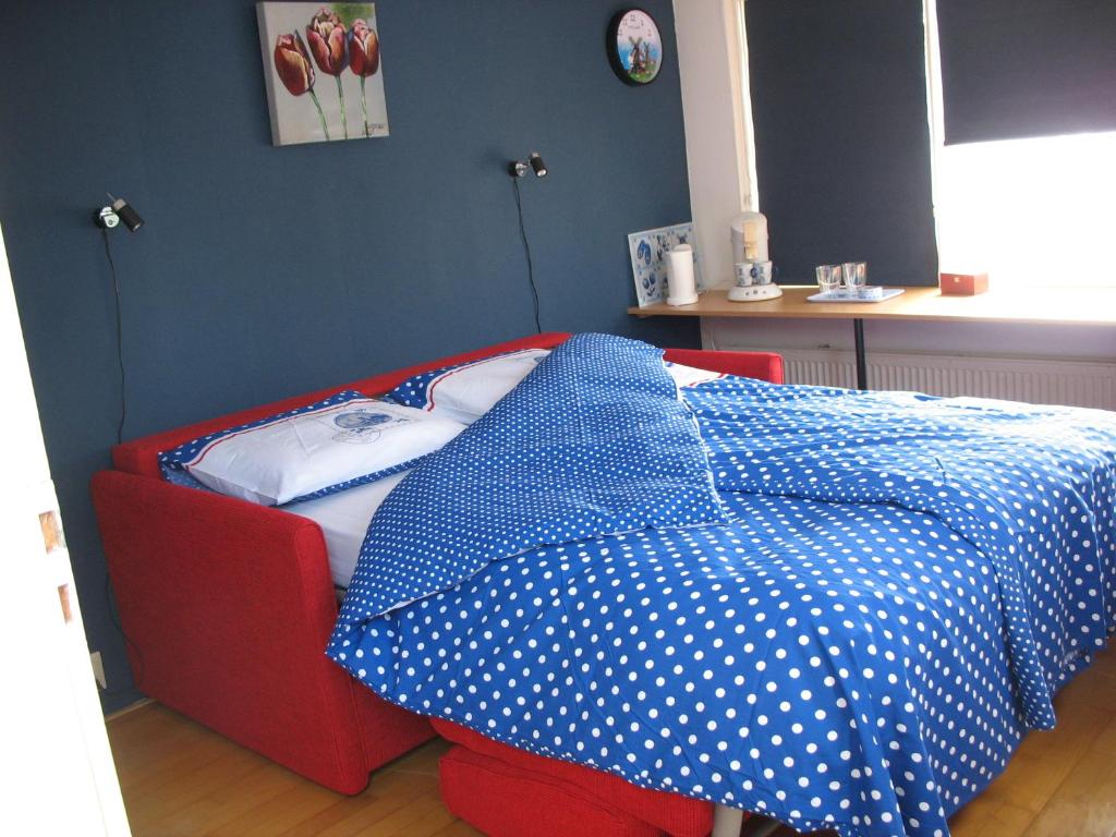 埃丹De Krasse Man的一张床上铺有蓝色和白色的波卡圆顶床单