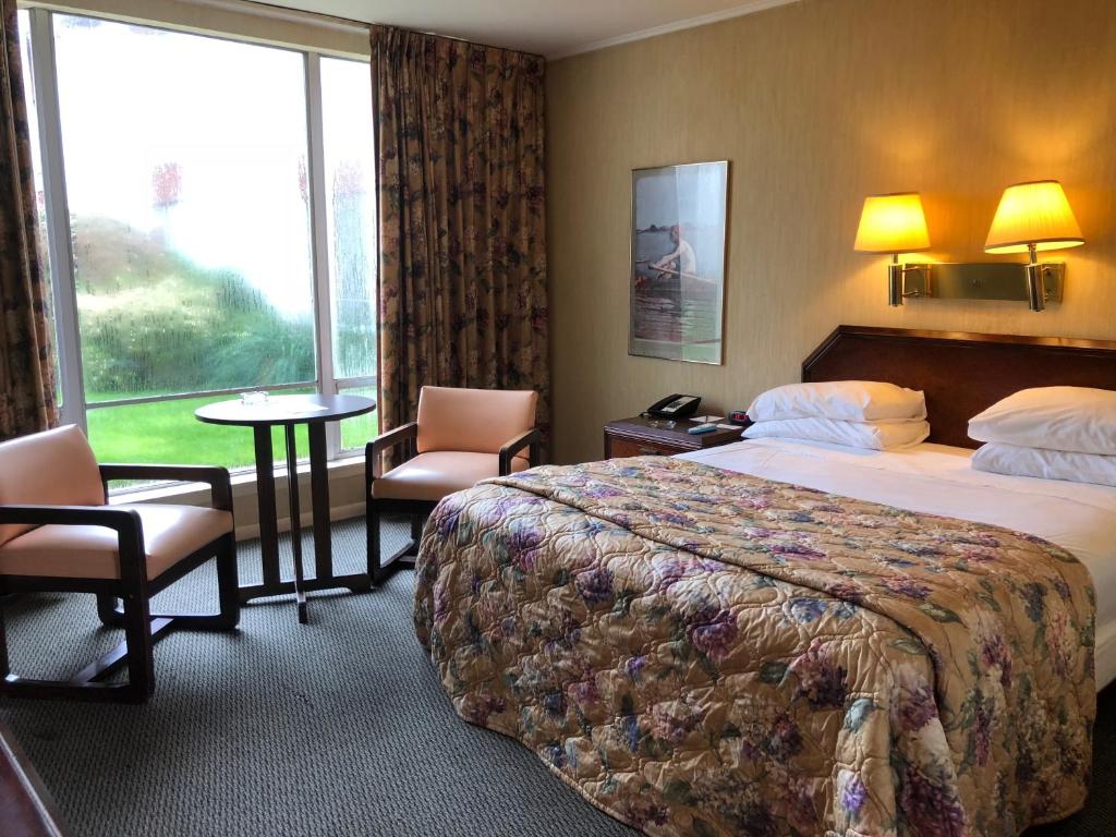 MerrickGateway Inn的酒店客房带一张床、一张桌子和椅子