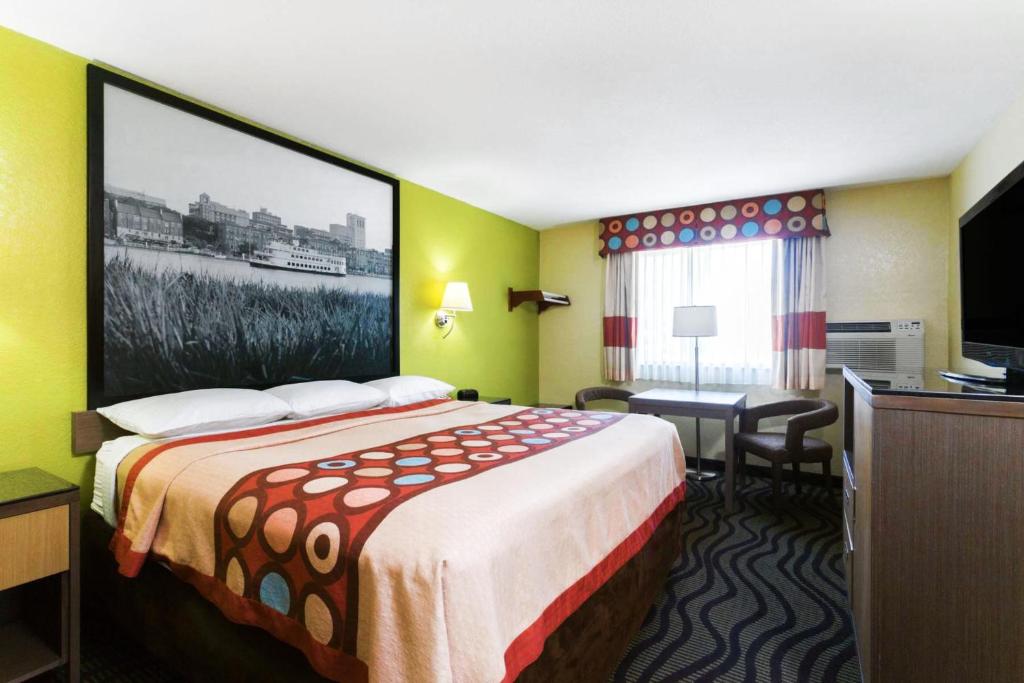 布伦瑞克布伦瑞克速8酒店的酒店客房设有一张床,墙上挂着一张大照片
