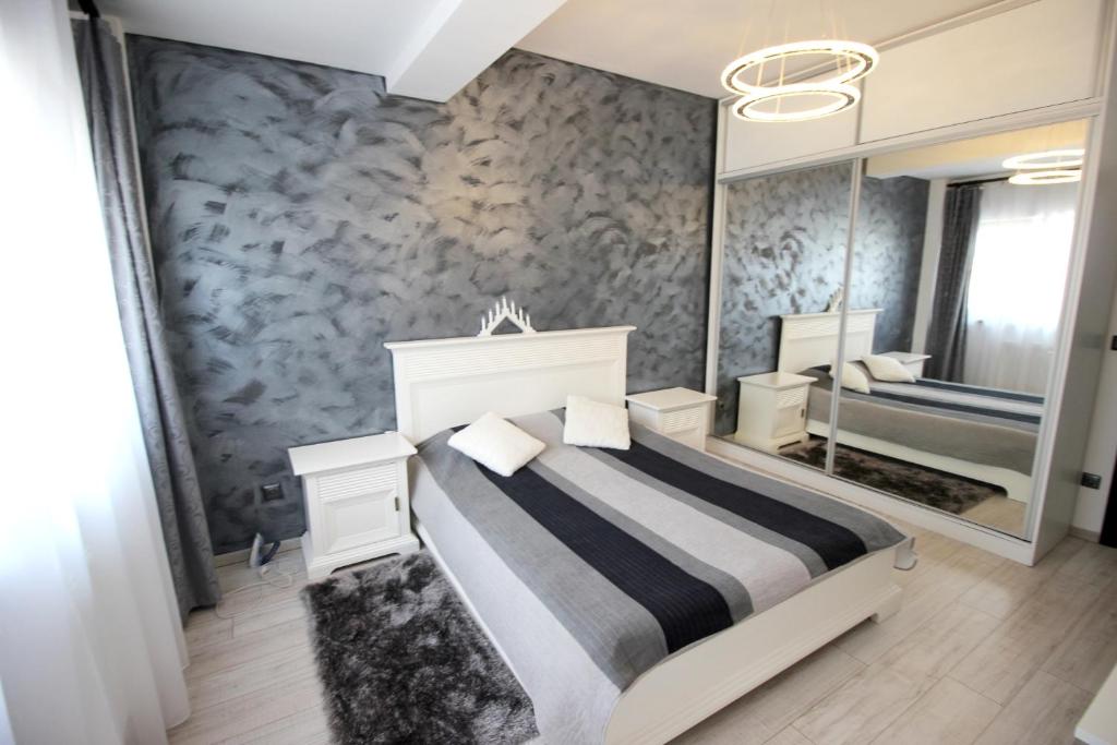 特尔古穆列什Apartament Diana的一间卧室配有一张床和一面大镜子