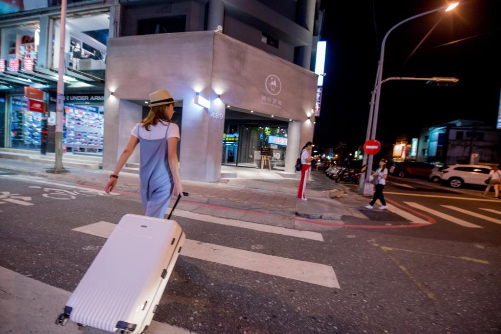 花莲市微停宿旅的带着手提箱走在街对面的女人