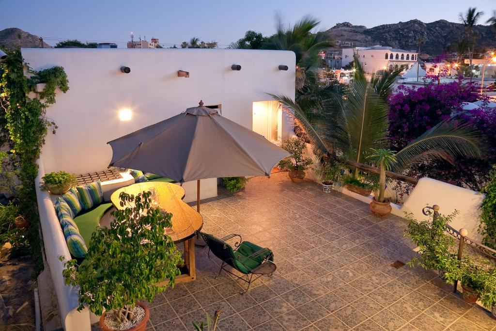 卡波圣卢卡斯Los Milagros Hotel的一个带沙发和遮阳伞的庭院
