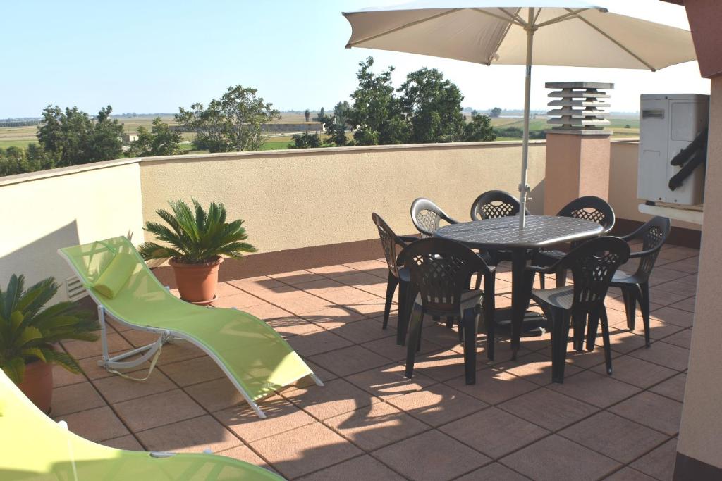 卡马尔莱斯Apartament Montse的庭院配有桌椅和遮阳伞。