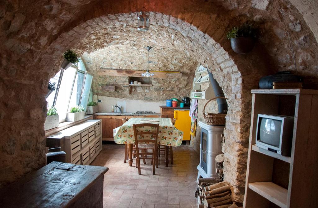 加尔多内-里维耶拉Charming rustic house的厨房设有拱门、桌子和电视