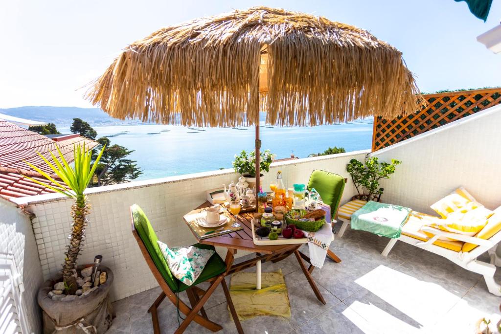 萨米艾拉El Balcon de las Rias Baixas的庭院配有桌椅和遮阳伞。