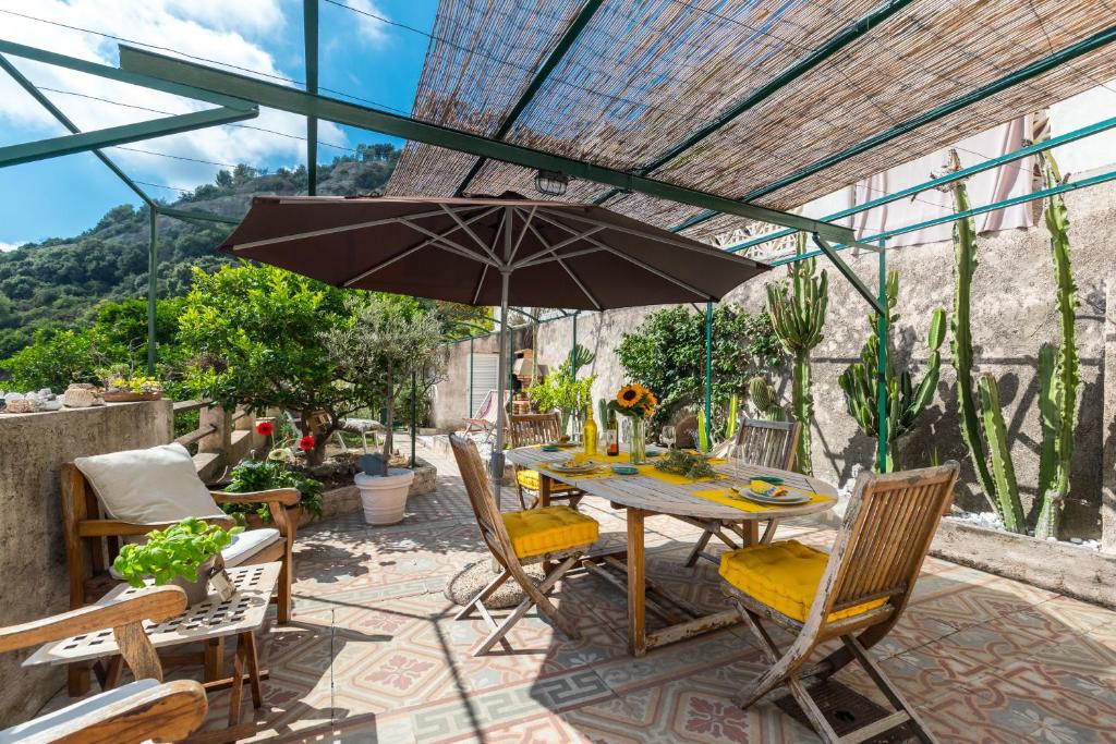 芒通La maison des vacances的庭院内桌椅和遮阳伞