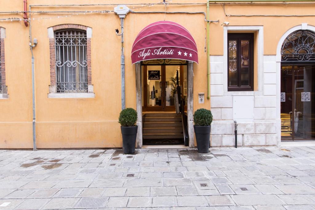 威尼斯阿格里阿迪斯提酒店的一座带紫色遮篷的建筑的前方商店