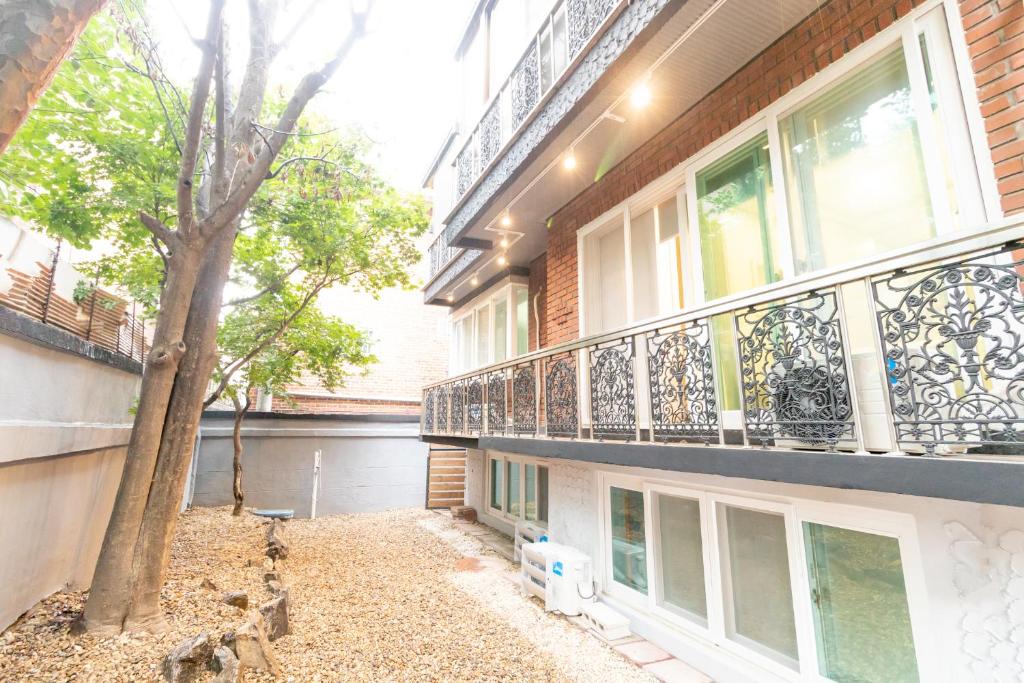 首尔Dawoo House 1 in Hongdae的公寓大楼设有阳台和树