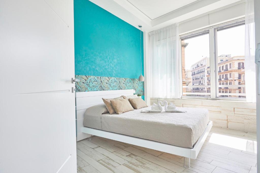 那不勒斯Luxury Experience | WelcHome Napoli的一间卧室设有一张床和蓝色的墙壁