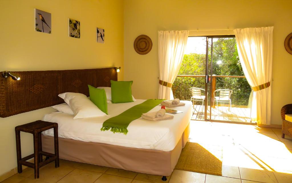 赫卢赫卢韦阿梅堪比旅舍的一间卧室配有一张带绿色枕头的大床