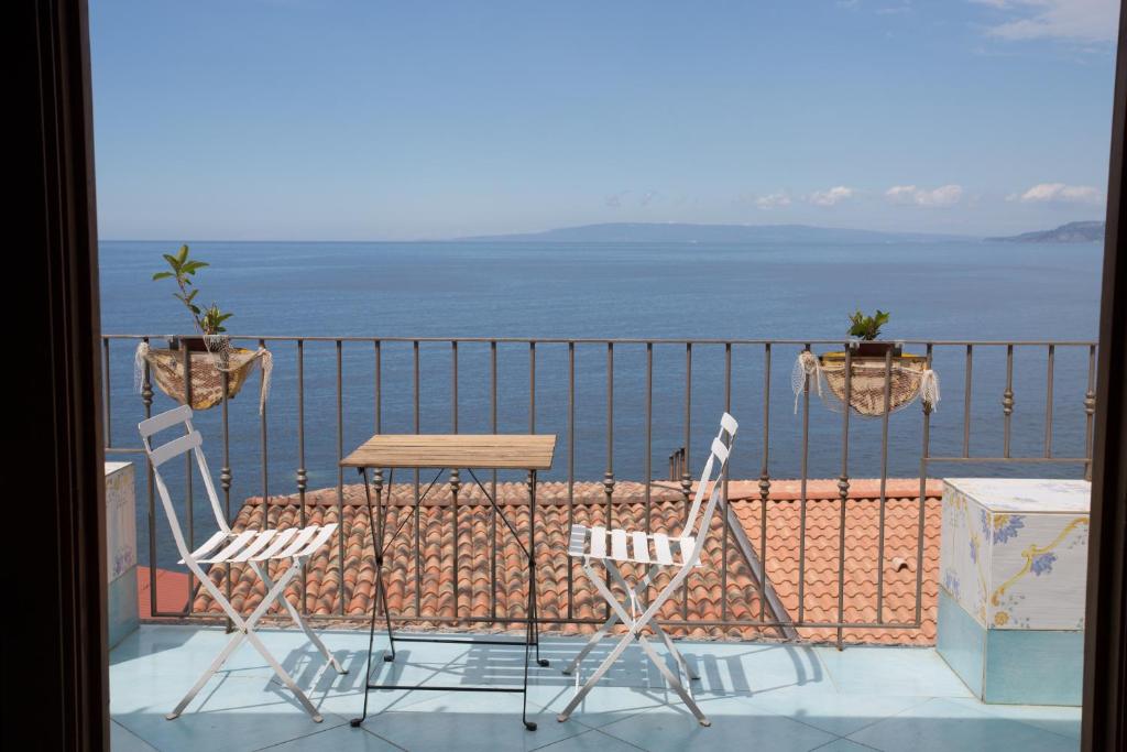 希拉卡萨维拉住宿加早餐旅馆的俯瞰大海的阳台配有两把椅子和一张桌子