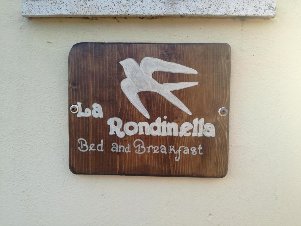 MontecerboliB&B La Rondinella的建筑物一侧的标志