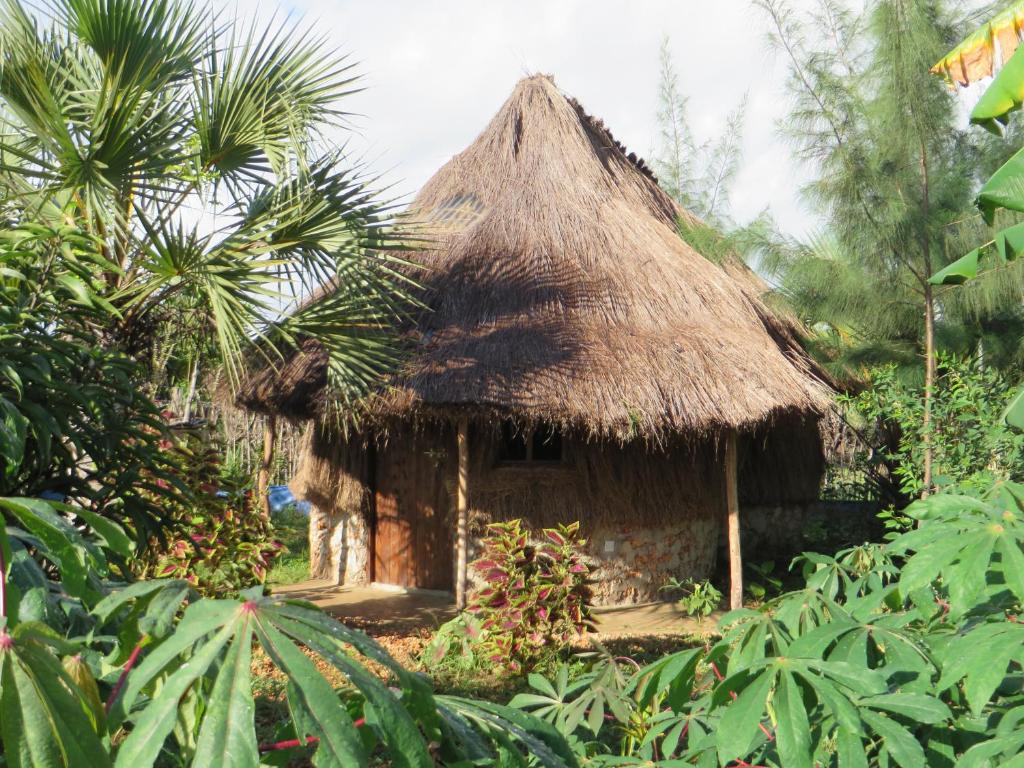 迪亚尼海滩Bahati Diani House Glamping的丛林中带茅草屋顶的小小屋