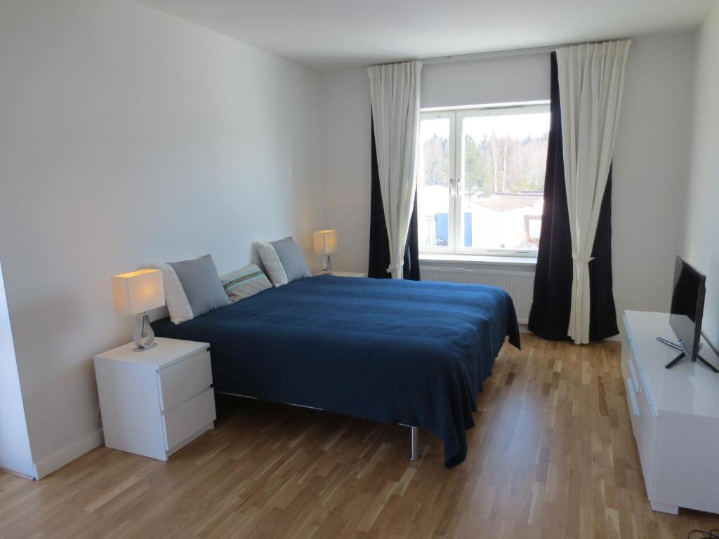东哈尔马Gamla Järnhandeln - Norrskedika Hotell的一间卧室设有蓝色的床和窗户。