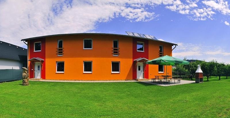 利普托斯基米库拉斯Privat Monika的一座大型橙色房子,设有绿色的草地庭院