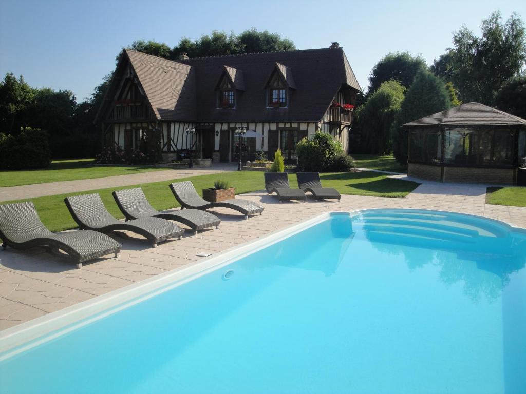 Fatouville-Grestain哥伦巴格斯度假别墅的一个带躺椅的游泳池以及一座房子