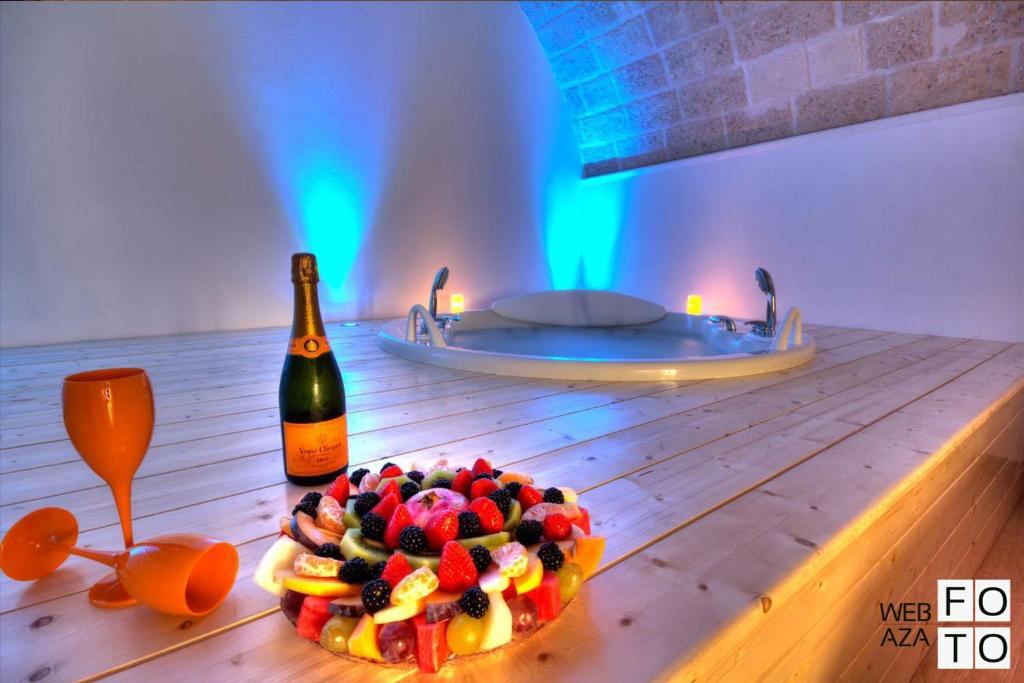 莫诺波利Suite Stone Luxury的一张桌子,上面放着蛋糕和一瓶葡萄酒