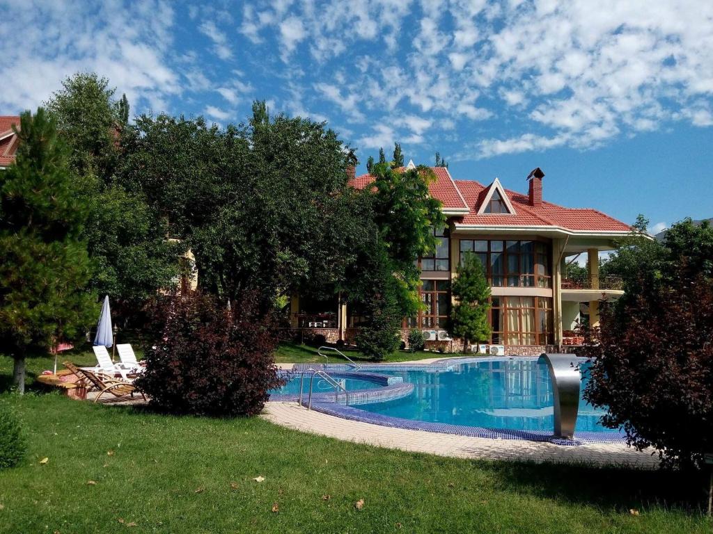 YusufkhonaGreen Canyon Uzbekistan的一座大房子,前面设有一个游泳池