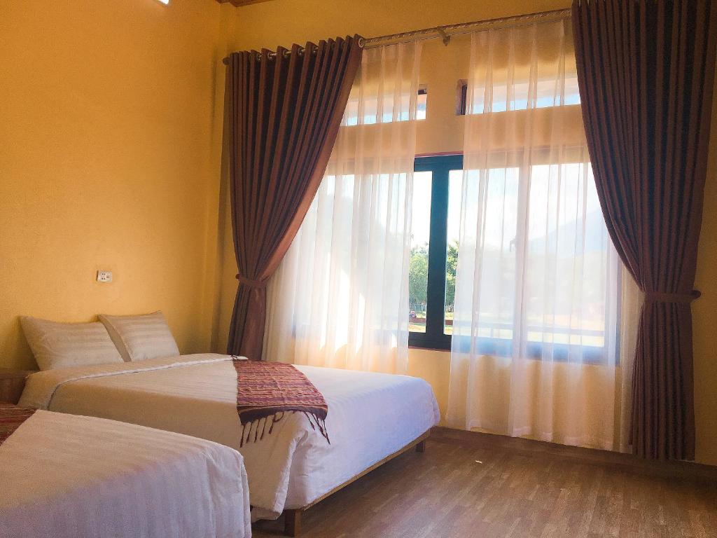 枚州县Mai Chau Xanh Bungalow的一间卧室设有两张床和大窗户