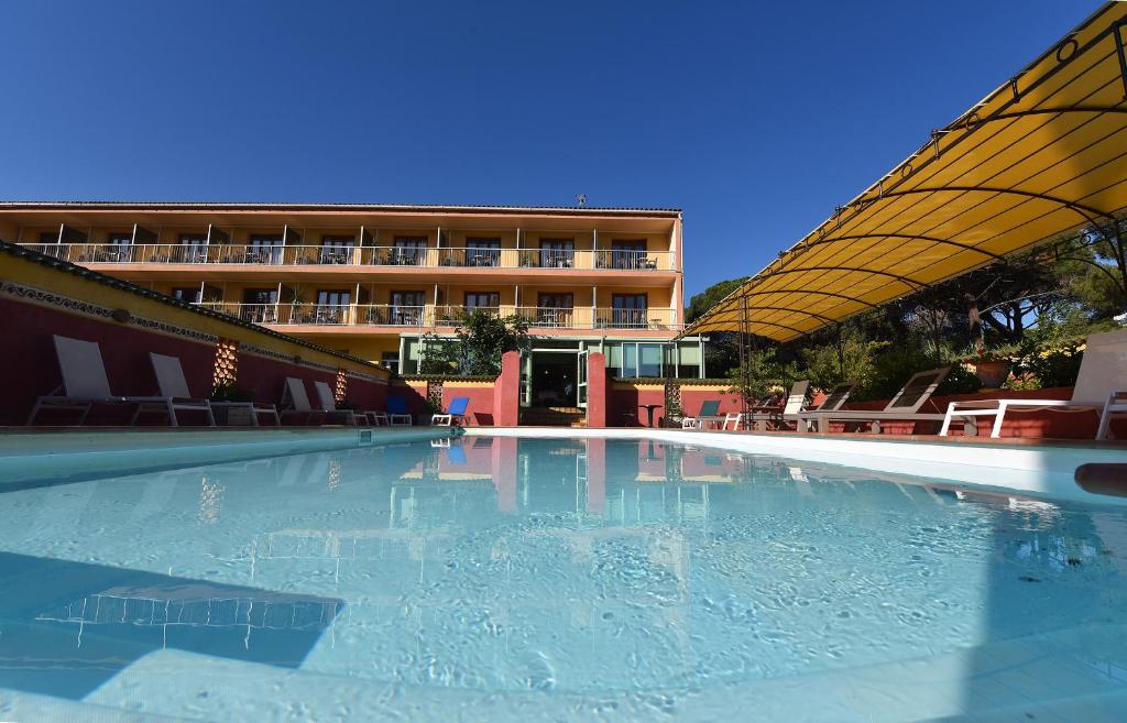 卡尔维Hotel Cyrnea的一座大楼前空的游泳池