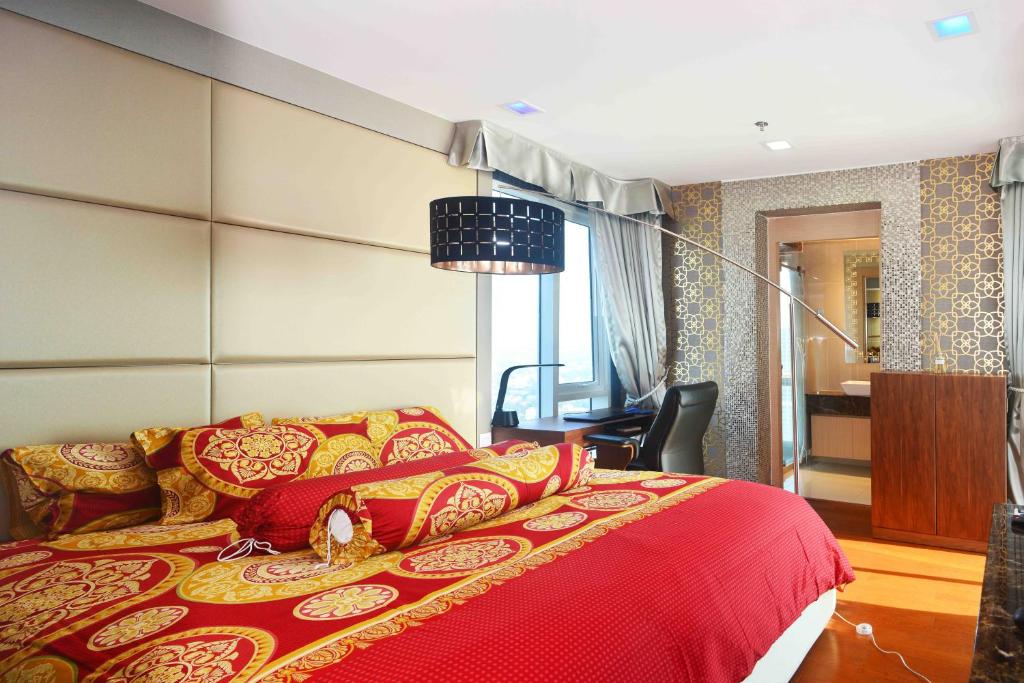北芭堤雅Lux SL Luxury Style of Life 5的一间卧室配有一张红色床罩的床