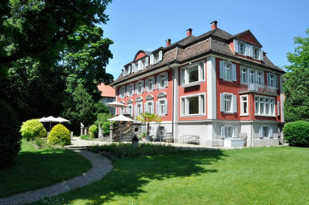 温特图尔Villa Jakobsbrunnen的一座红色和白色的大建筑,有草地庭院