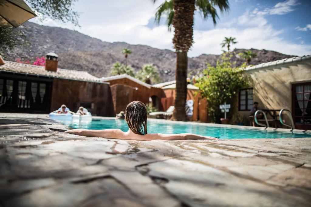 棕榈泉考卡酒店的躺在游泳池里的男人