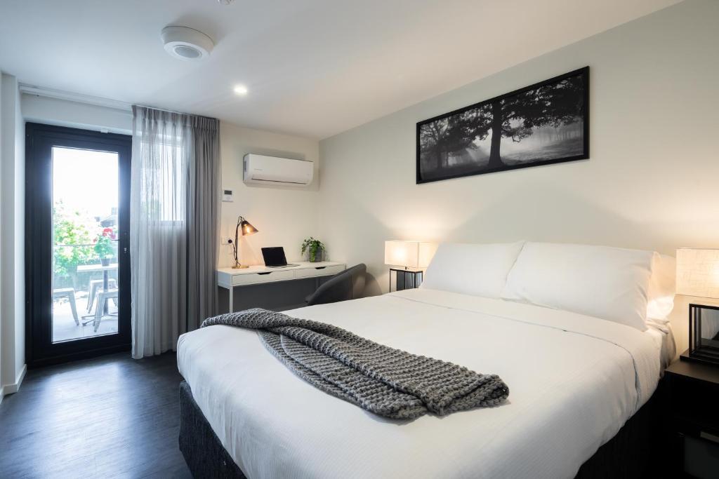布里斯班阿斯科特廉价汽车旅馆的卧室设有一张白色大床和一扇窗户。