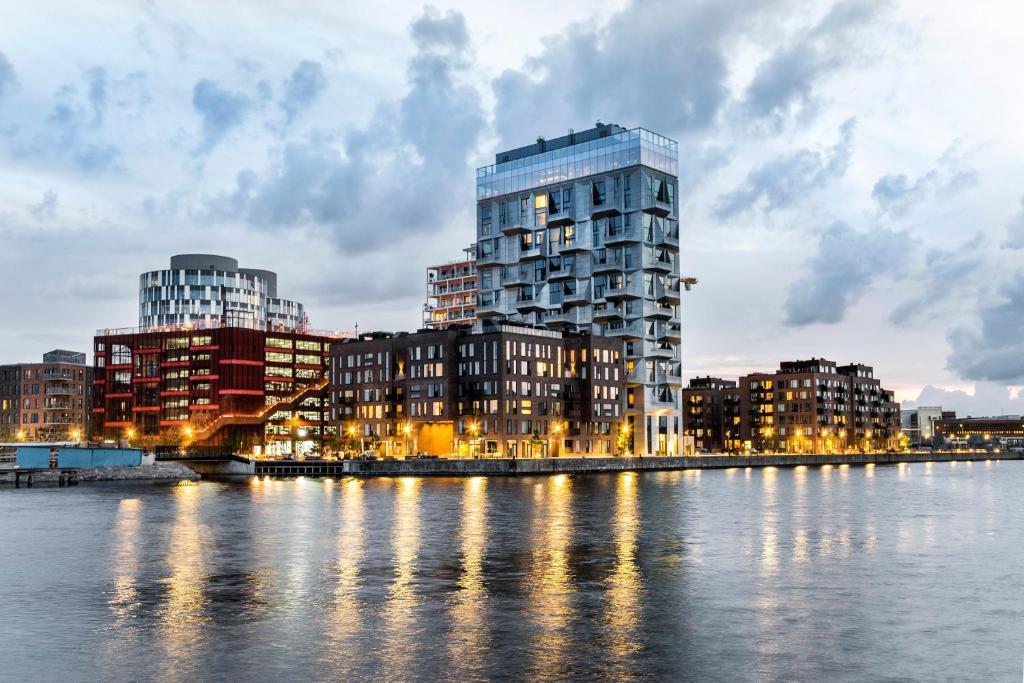 哥本哈根海港留宿公寓的一座高大的建筑,毗邻一条有建筑物的河流