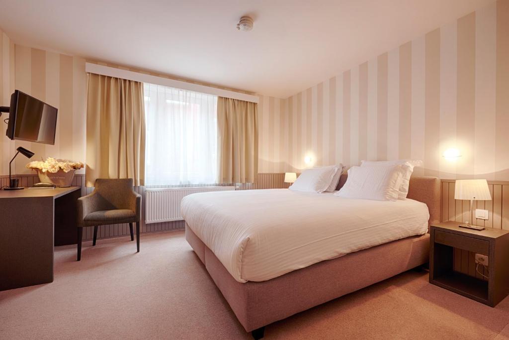 布鲁日普耶酒店的酒店客房设有一张大床和一张书桌。