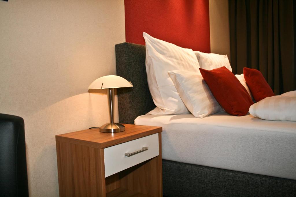 巴德塞尔佐根伊丽莎白小屋宾馆的酒店的客房 - 带红色和白色枕头的床