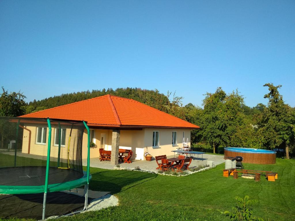 HeřmaničkyHoliday House Adrelot的一座带蹦床的橙色屋顶的房子