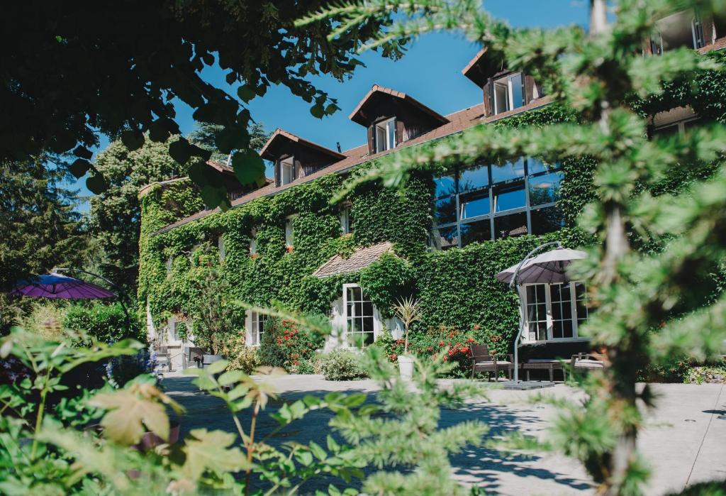 加普翠壁酒店的常春藤覆盖着窗户和植物的建筑