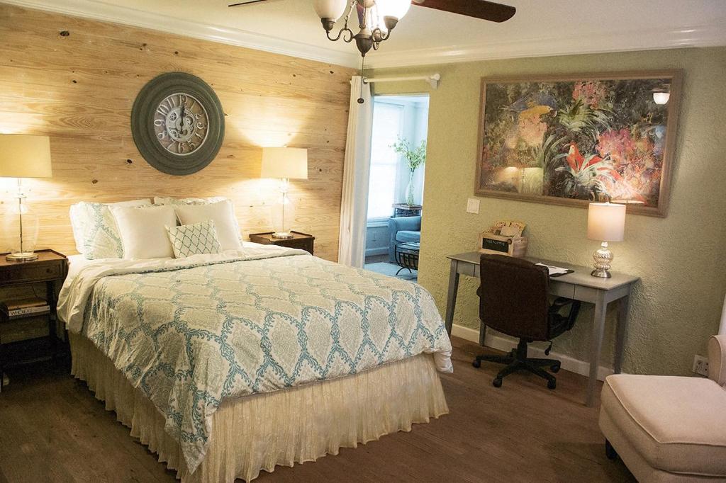 奥兰多Winter Park charm的一间卧室配有一张床、一张桌子和一把椅子