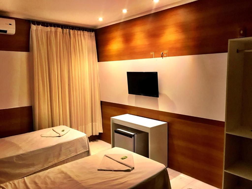 莫索罗Hotel Terra do Sal的酒店客房设有两张床和电视。