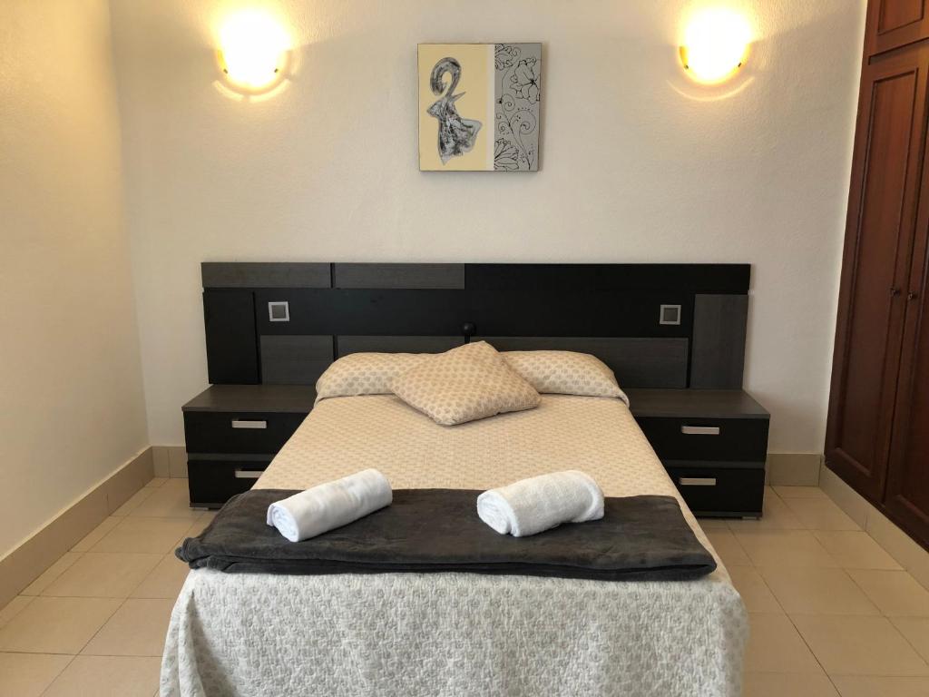 洛雷多Hotel Costa Mar的一间卧室配有一张床,上面有两条毛巾