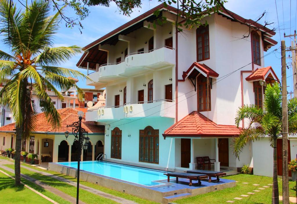 尼甘布时尚假日酒店 的一座带游泳池和度假村的别墅