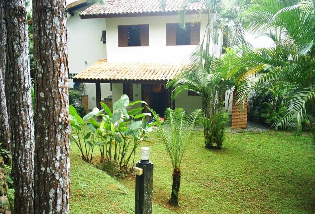 博西坎加CASA CONDOMÍNIO FECHADO的棕榈树花园内的房子