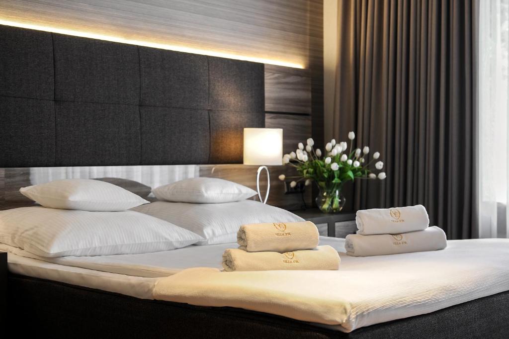 格但斯克Hotel Villa Eva的卧室配有带白色枕头的大床