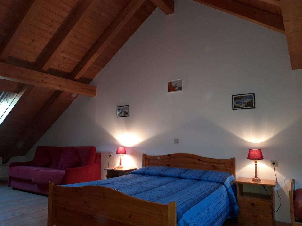 维拉巴萨Residenze Sonnenschein Casa Rossa的一间卧室配有一张床和一张红色的沙发