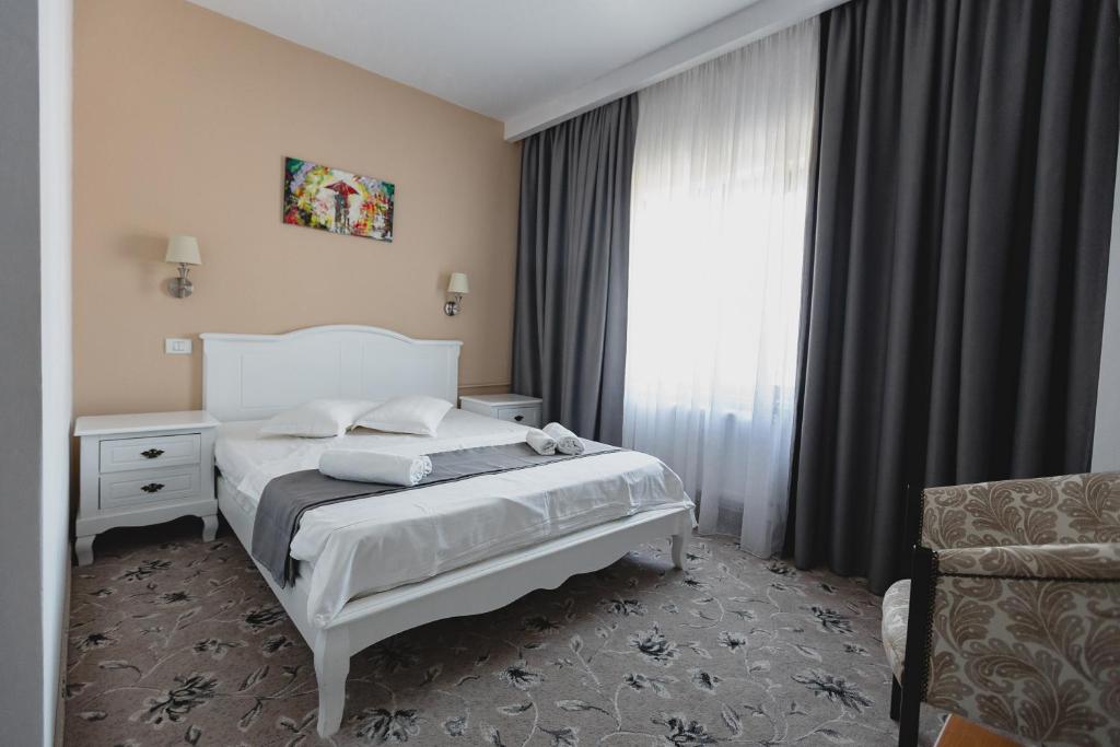 Afumaţi克里斯蒂安酒店的卧室配有白色的床和窗户。