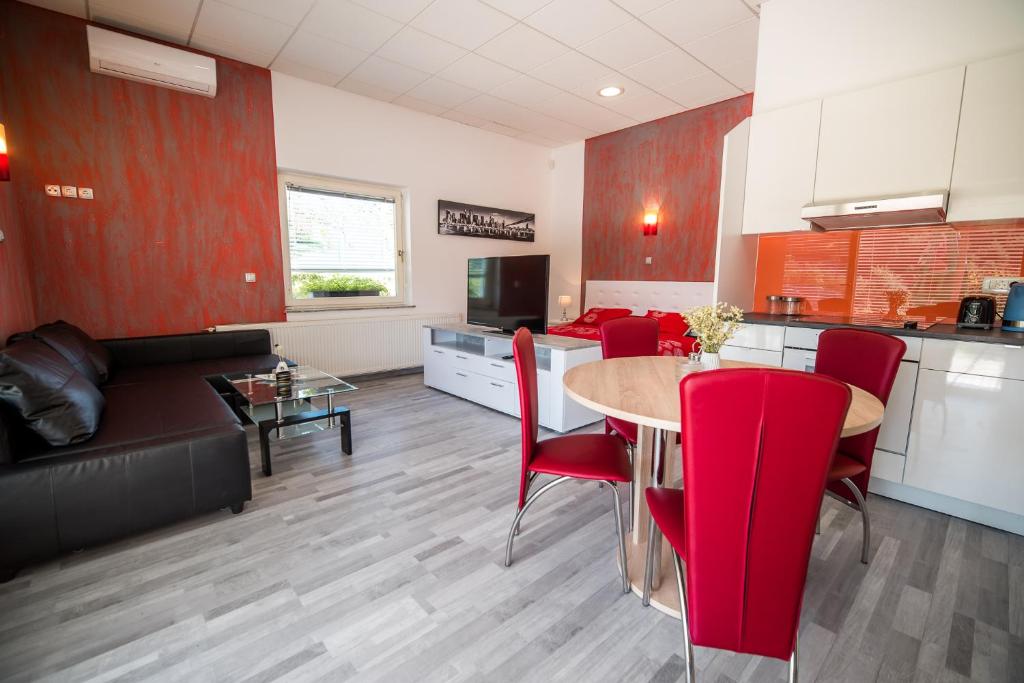 斯玛杰克托莱塞Apartment Lucija-Terme Šmarješke Toplice的厨房以及带桌子和红色椅子的用餐室。