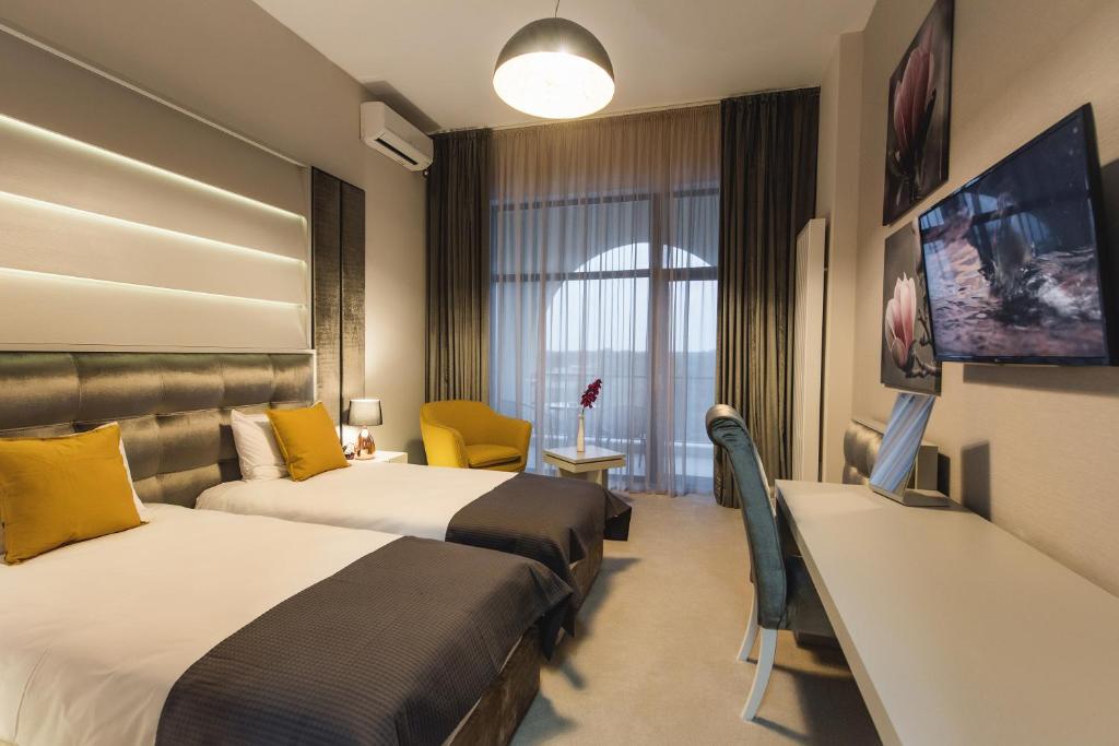 亚历山德里亚Hotel Edma的酒店客房设有两张床和一台平面电视。