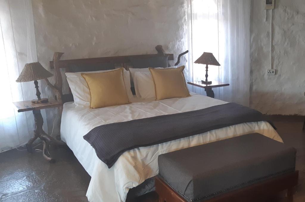 拉塞利亚Annie's Place, Lanseria的一间卧室配有一张大床和两盏灯