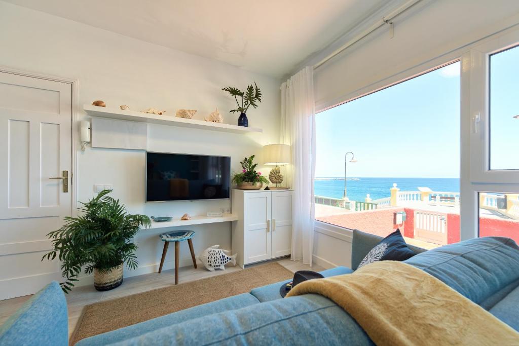 梅莱纳拉Casa Antonia by the beach Melenara的客厅配有蓝色沙发,享有海景