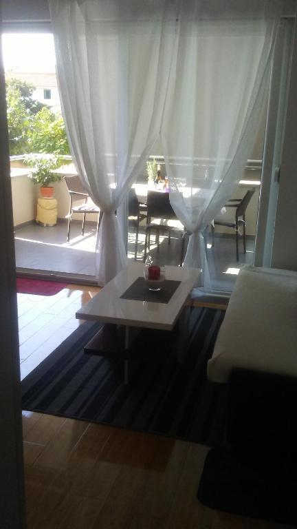 诺瓦利娅Apartman Bruna的客厅,窗户前配有桌子