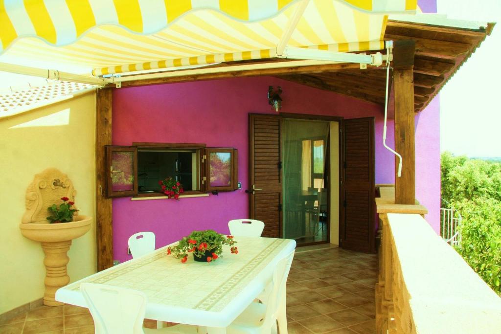 夏卡Casa Vacanze Surriano的庭院设有白色桌子和粉红色的墙壁